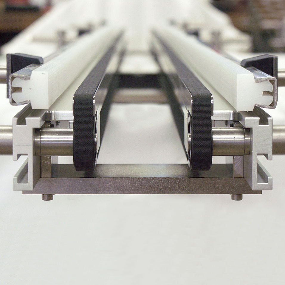 Spezielles Doppelgurt-Förderband mit Freistellung zwischen den Gurten. - Special double belt conveyor features a space between the belts.